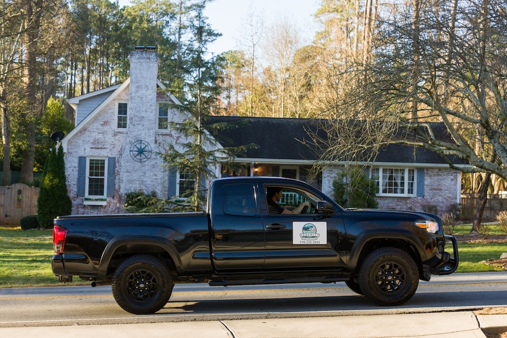 A branded Serenity Home Inspections pickup truck parked in the driveway of a residential home.